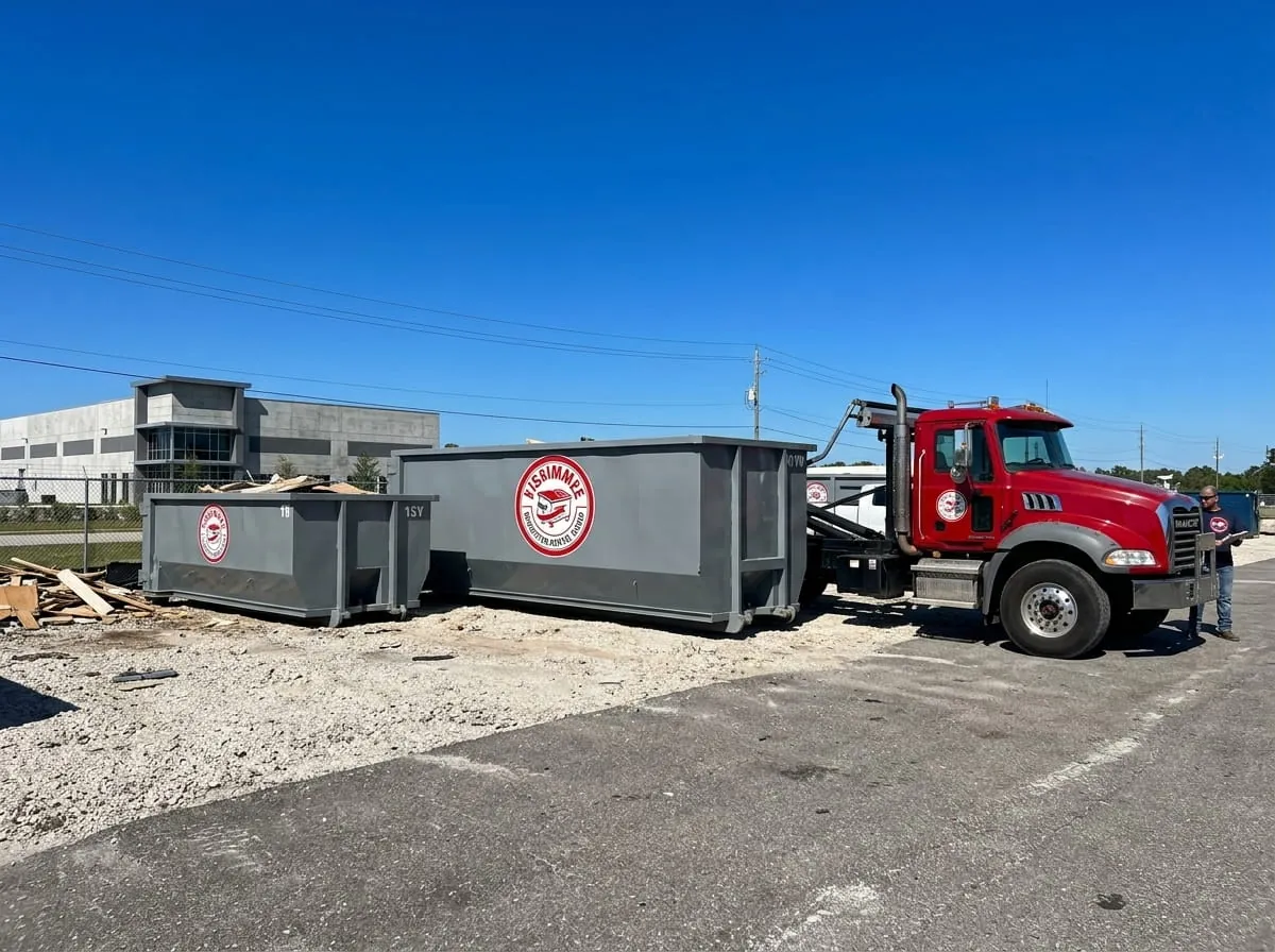 Roofing shingles being loaded into a roll-off dumpster during a tear-off in Kissimmee, Florida